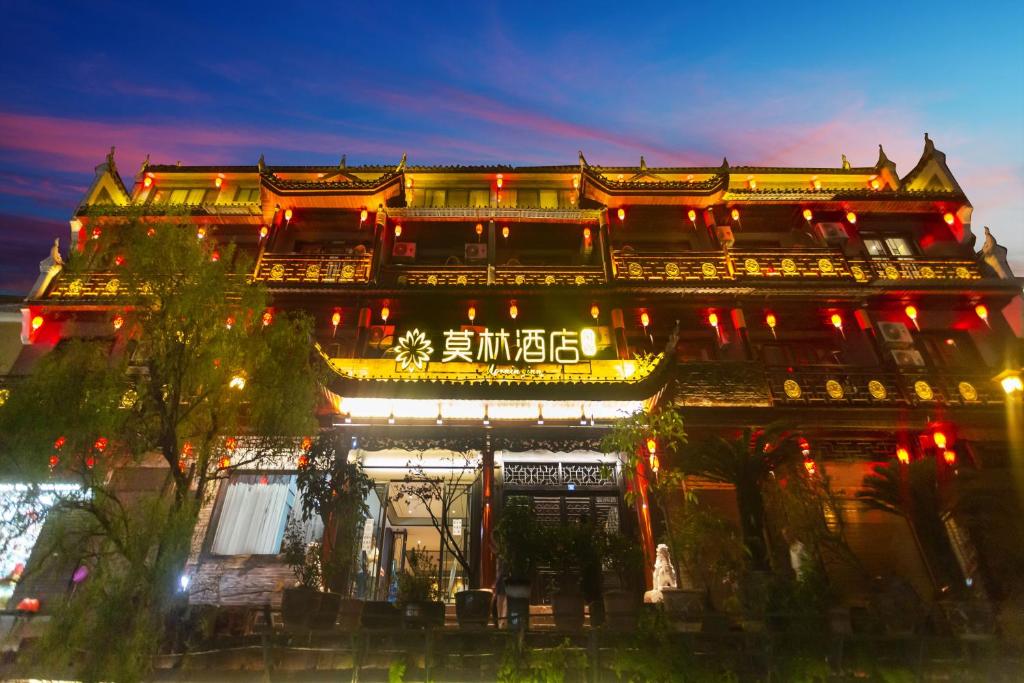 un edificio asiático con luces encendidas por la noche en Morninginn, Phoenix Ancient City Tuojiang, en Fenghuang