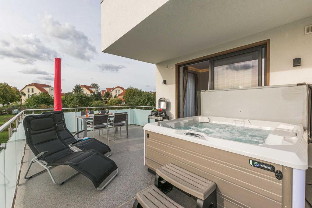 a hot tub on the deck of a house at Luxus_SPA_OG_Fewo DREAMTIME _WE 3_ in Göhren-Lebbin
