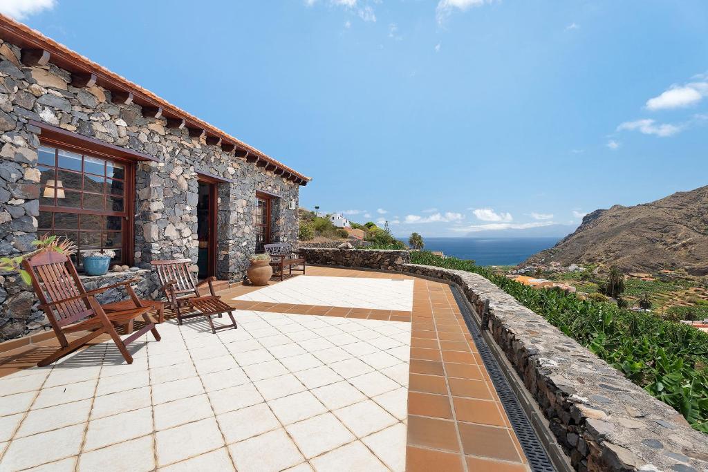 a stone house with a view of the ocean at Finca Los Tableros in Hermigua