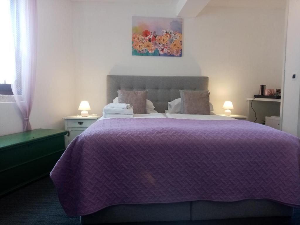 ein Schlafzimmer mit einem lila Bett mit einer lila Decke in der Unterkunft Rooms Serafin in Motovun