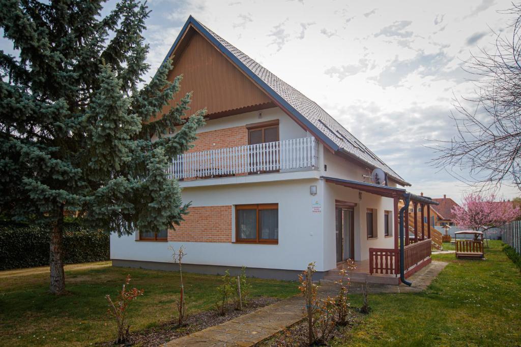 ein Haus mit einem Balkon an der Seite in der Unterkunft Olivia Apartment House in Balatonboglár