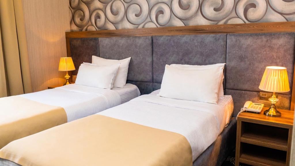 Postel nebo postele na pokoji v ubytování Grand Midway Hotel