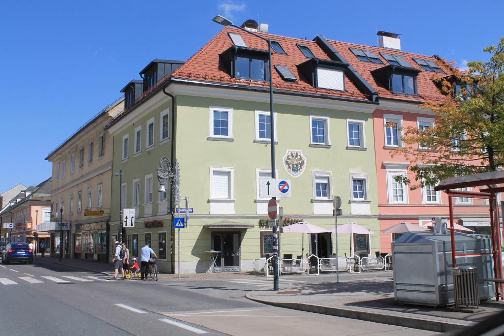 een groot gebouw met een rood dak in een stadsstraat bij Stadtresidenz Salburg in Klagenfurt