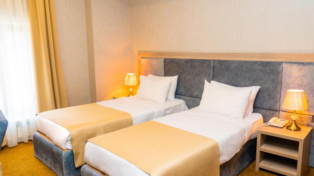 Postel nebo postele na pokoji v ubytování Grand Midway Hotel