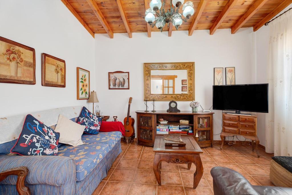 a living room with a couch and a flat screen tv at Rosa del Negro in Alojera