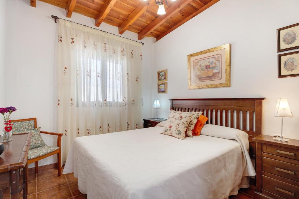 a bedroom with a bed and a desk and a window at Rosa del Negro in Alojera