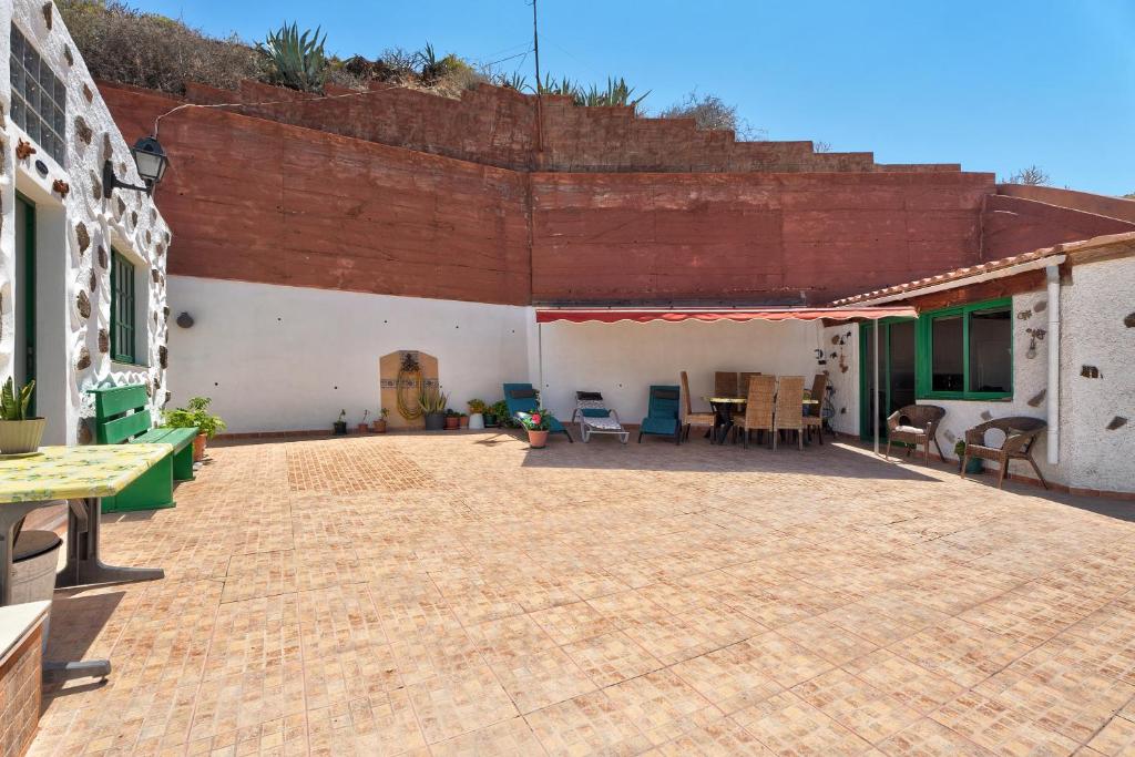 a patio with chairs and tables in a building at Rosa del Negro in Alojera