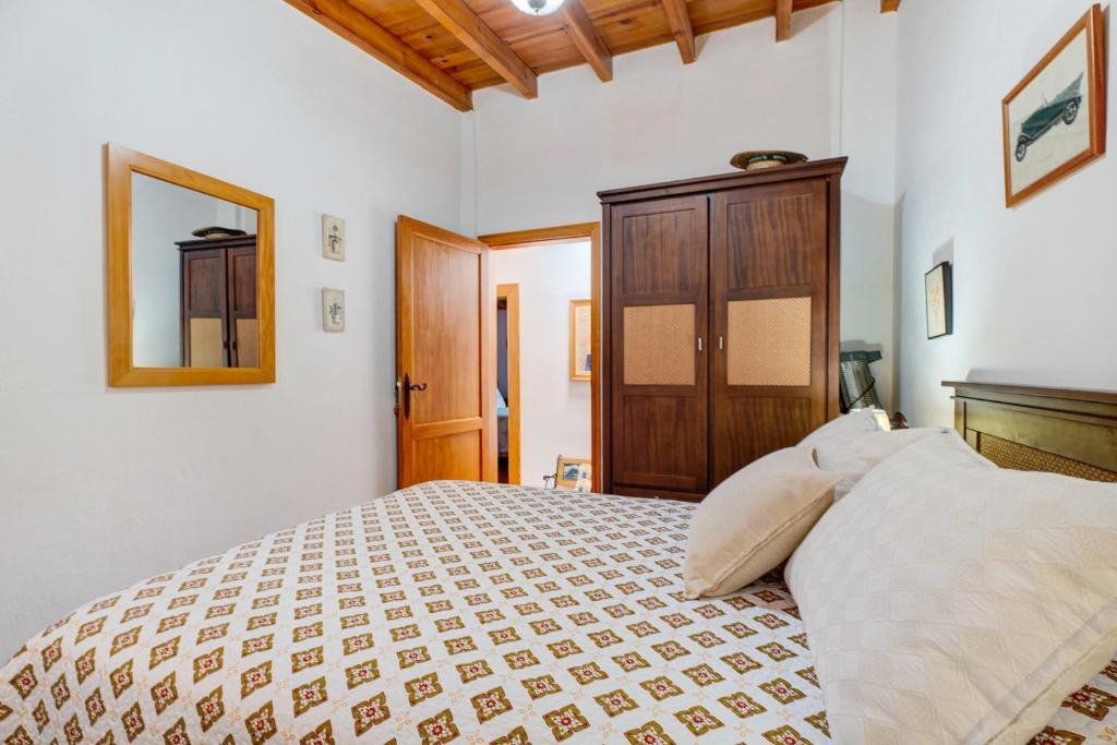 a bedroom with a large bed and a wooden cabinet at Rosa del Negro in Alojera