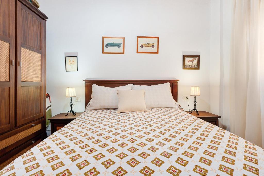 a bedroom with a large bed with two lamps at Rosa del Negro in Alojera