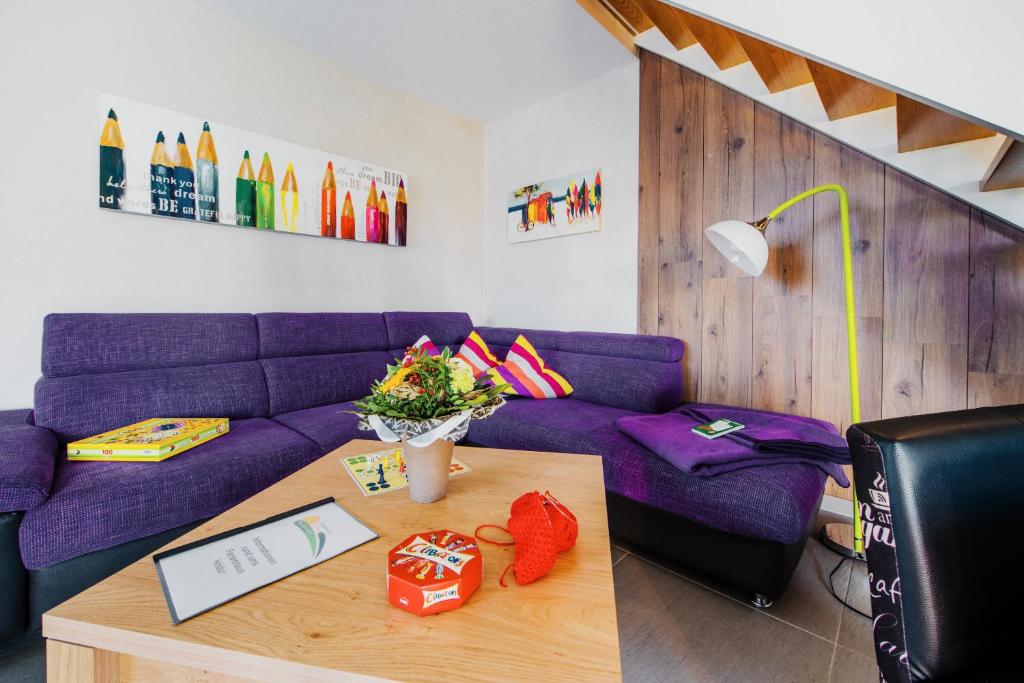 a living room with a purple couch and a table at Ferienhaus Hödur in Hasselfelde
