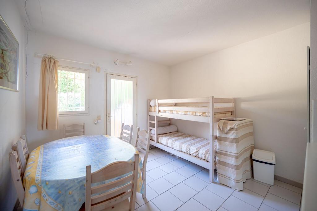Zimmer mit einem Tisch, einem Etagenbett und einem Tisch in der Unterkunft Romarin - Appt pour 4 voyageurs avec splendide vue mer in Le Lavandou