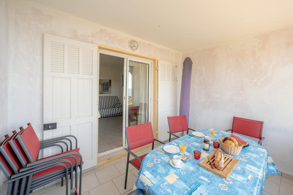 ein Esszimmer mit einem Tisch und roten Stühlen in der Unterkunft Romarin - Appt pour 4 voyageurs avec splendide vue mer in Le Lavandou