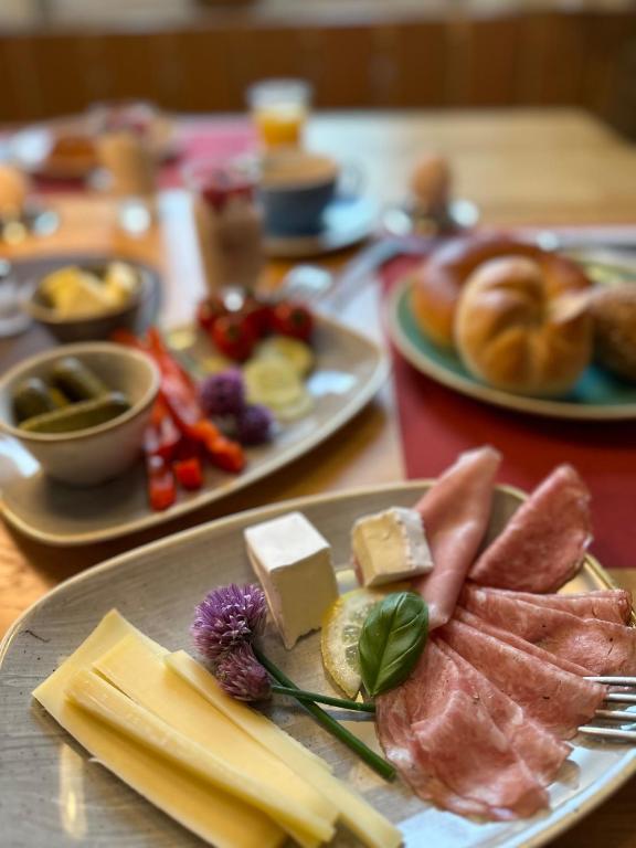 a table topped with plates of food with meats and cheese at Gasthof - Auszeit im Bad Diezlings - Adults only in Hörbranz