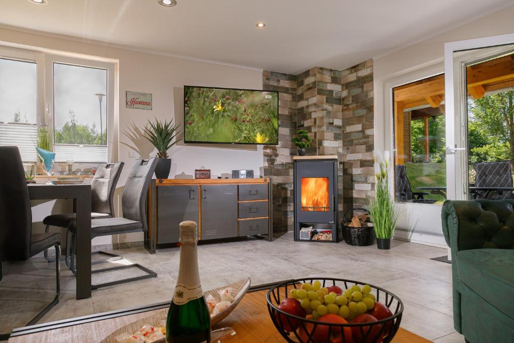a living room with a bottle of champagne and a fireplace at Premium-Plus-Ferienhaus Havanna Select in Hasselfelde