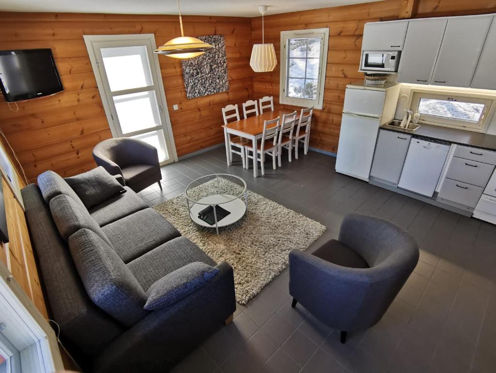 a living room with a couch and chairs and a kitchen at Rauhalahti Holiday Homes in Kuopio