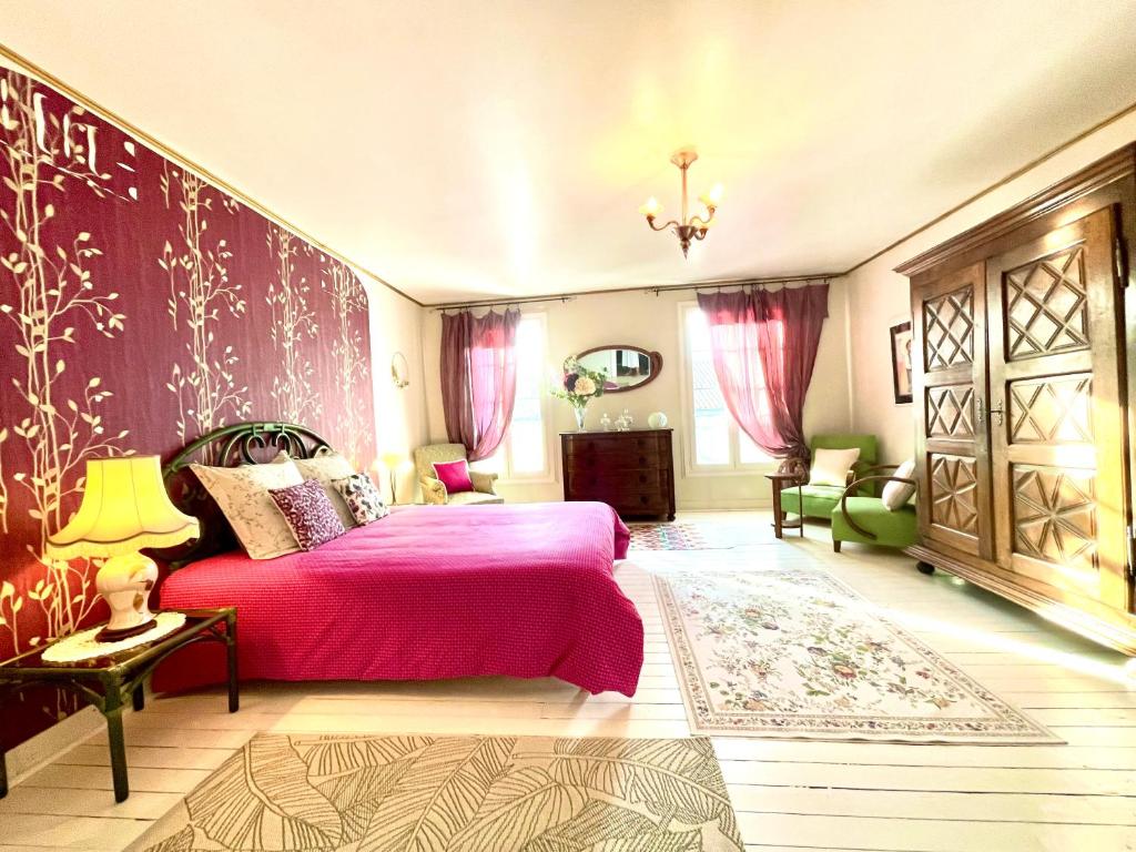sypialnia z łóżkiem i różową narzutą w obiekcie Maison B w mieście Bergerac