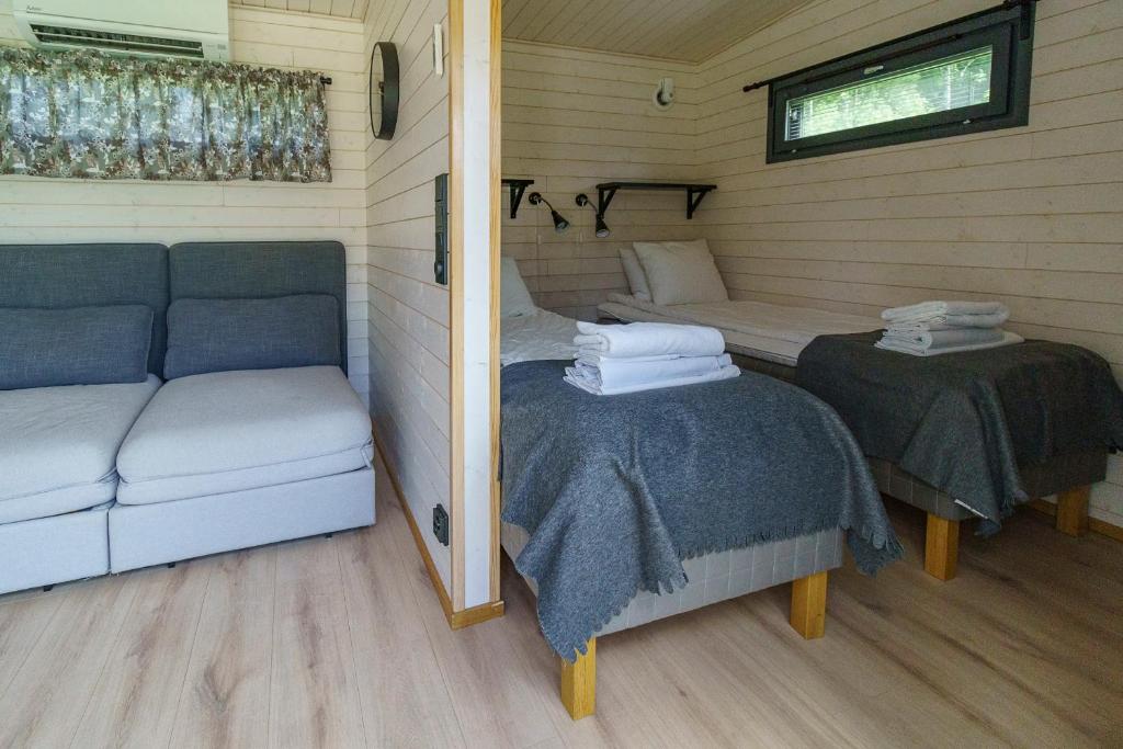 a room with two beds and a couch in a cabin at Rauhalahti Holiday Homes in Kuopio
