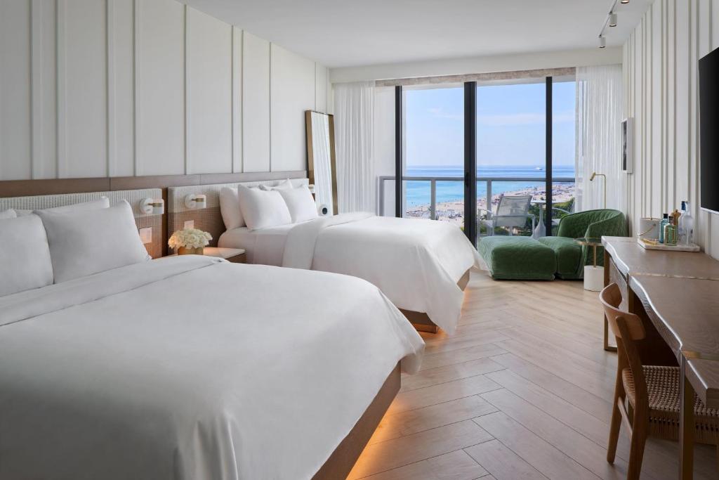 a hotel room with two beds and a balcony at W South Beach in Miami Beach