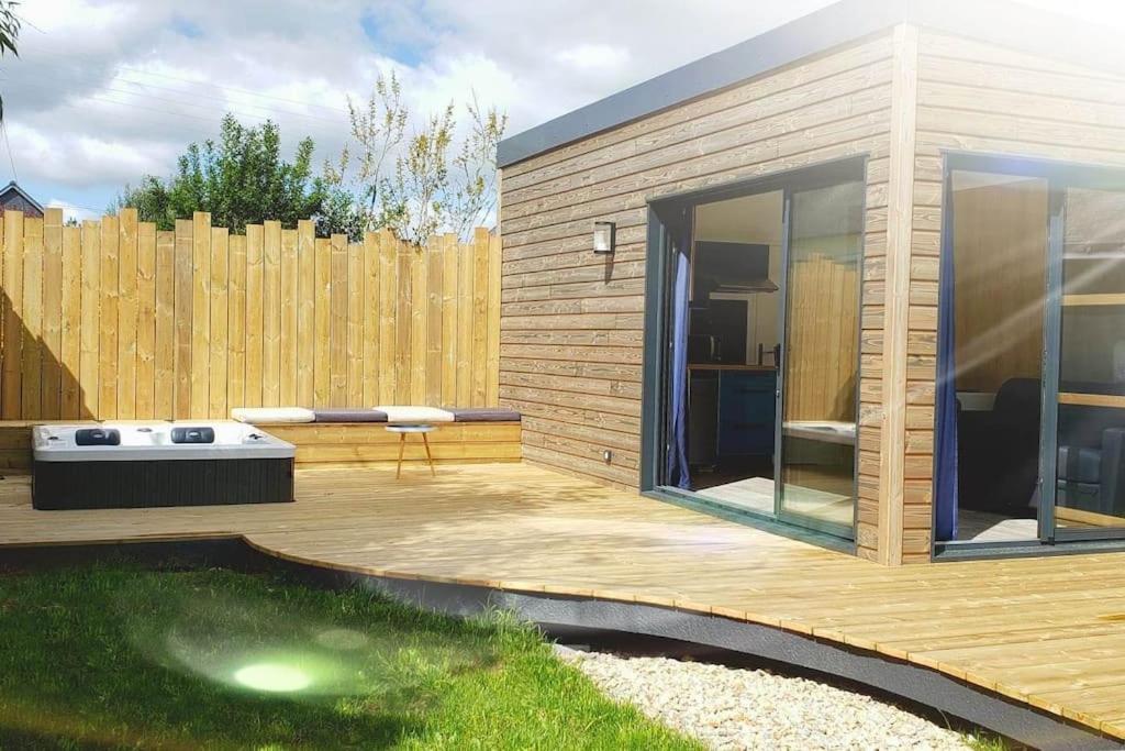 una pequeña casa con terraza y valla en Studio de jardin au calme en Hennebont