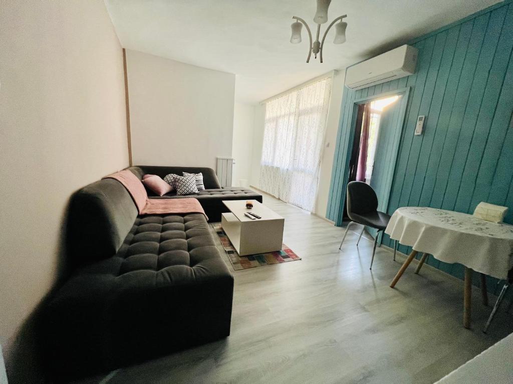 ein Wohnzimmer mit einem Sofa und einem Tisch in der Unterkunft Midtown Apartment in Kardschali