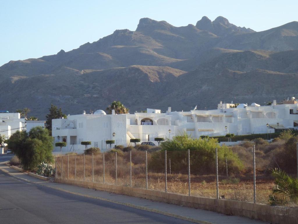 une rangée de bâtiments blancs avec des montagnes en arrière-plan dans l'établissement Apto El Palmeral Mojácar Playa, à Mojácar