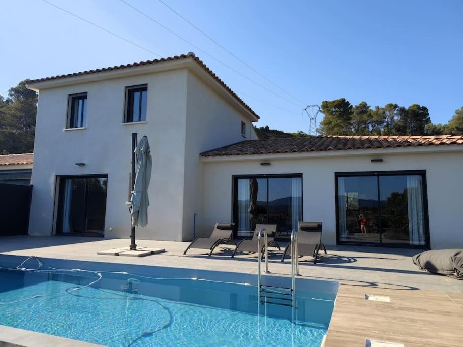 eine Villa mit einem Pool vor einem Haus in der Unterkunft Villa moderne, calme avec piscine proche d'Aix-en-Provence in Châteauneuf-le-Rouge