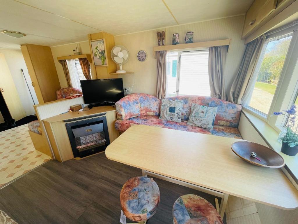 Caravana con sala de estar con sofá y mesa en Holiday Caravan Holle Poarte Makkum, en Makkum