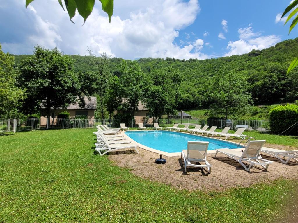 een zwembad met ligstoelen en een visor bij Village de 19 gites avec Piscine et restaurant, Grand Vabre Nature in Conques