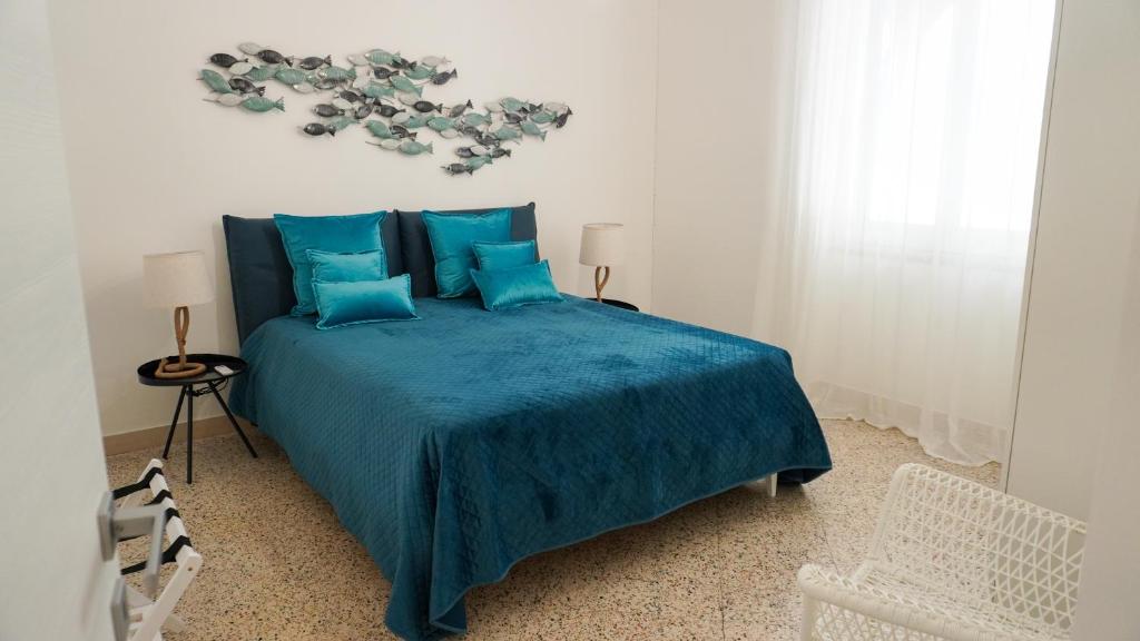 a bedroom with a bed with a blue comforter at Donna Elena House in Maiori