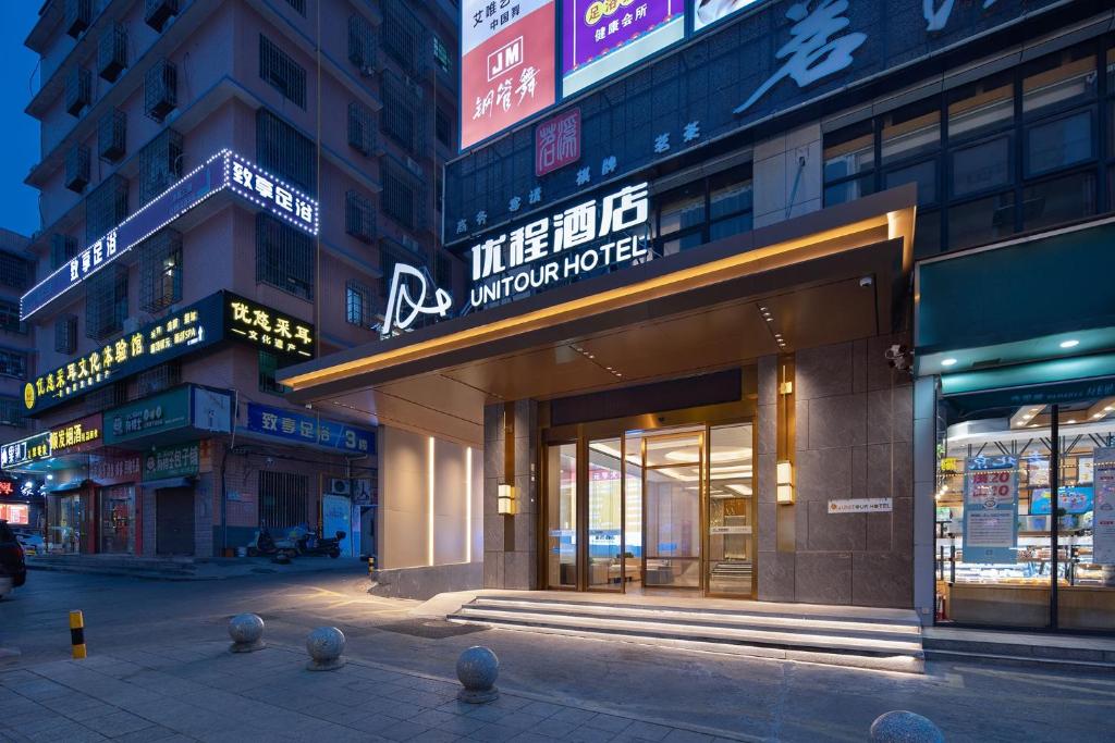 a store front of a building with signs on it at Unitour Hotel, Changsha Yanghu University of Traditional Chinese Medicine in Changsha