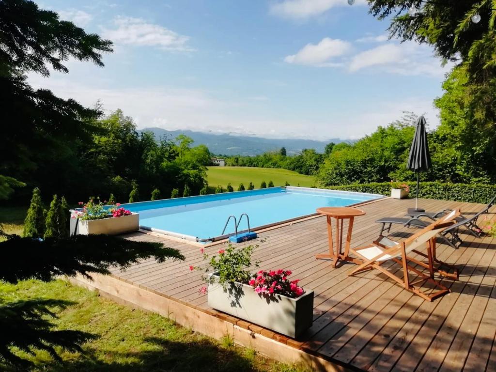 a wooden deck with a pool and a table and chairs at Torretta Silva in Belluno