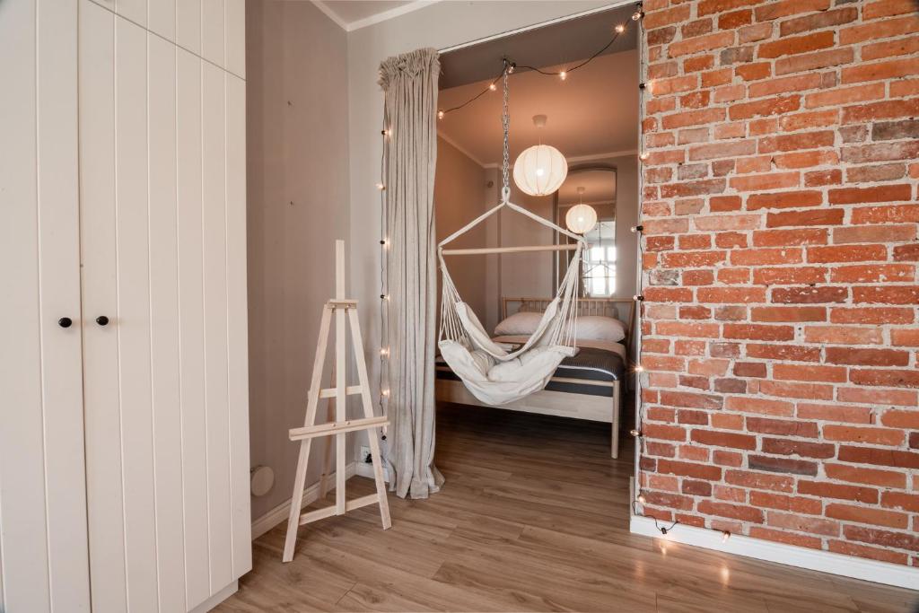 a room with a hammock hanging from a brick wall at KING APART Gliniana 58 in Wrocław