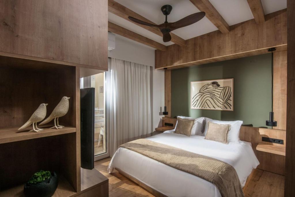 Schlafzimmer mit einem Bett und einem Deckenventilator in der Unterkunft Relaxo Collection Luxury Suites in the Heart of Heraklion in Iraklio