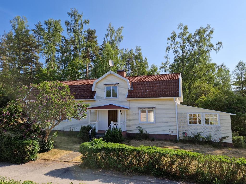 Casa blanca con techo rojo en Ferienhaus in Lönneberga, en Lönneberga
