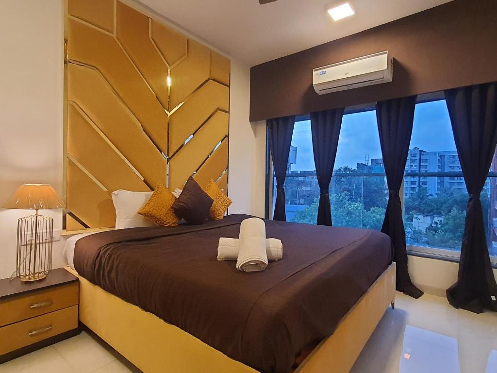 um quarto com uma cama grande e uma janela grande em OSI Apartments Santacruz em Mumbai