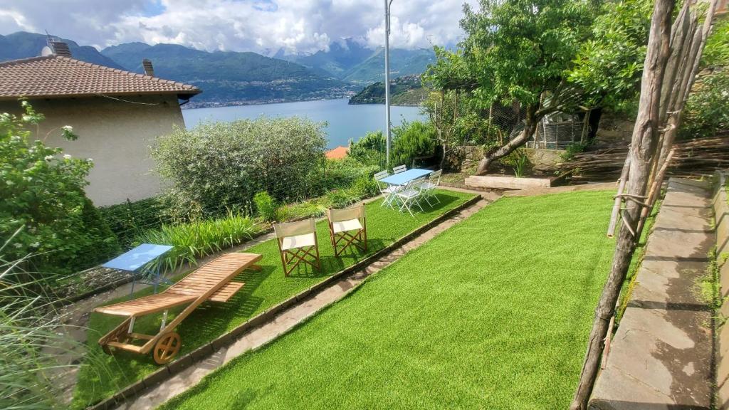 een tuin met een bank en stoelen en een meer bij Sopravento Lake View- La Breva in Dorio
