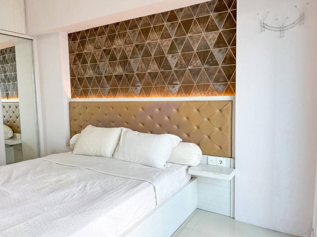 ein Schlafzimmer mit einem Bett und einer Wand mit Fliesen in der Unterkunft Arva Home in Surabaya