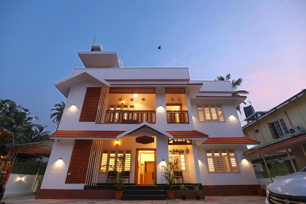 una gran casa blanca con luces encendidas en Choice Beach House, en Kannur
