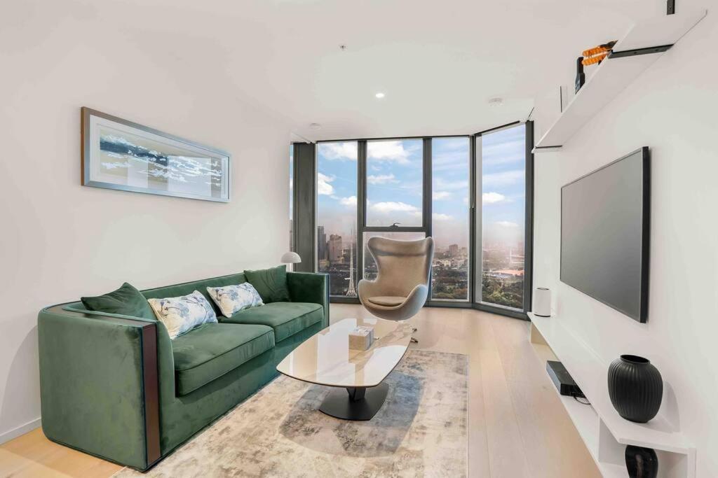 sala de estar con sofá verde y TV en Glamorous 2BR Southbank home LV50! stunning view#MSQ5003, en Melbourne