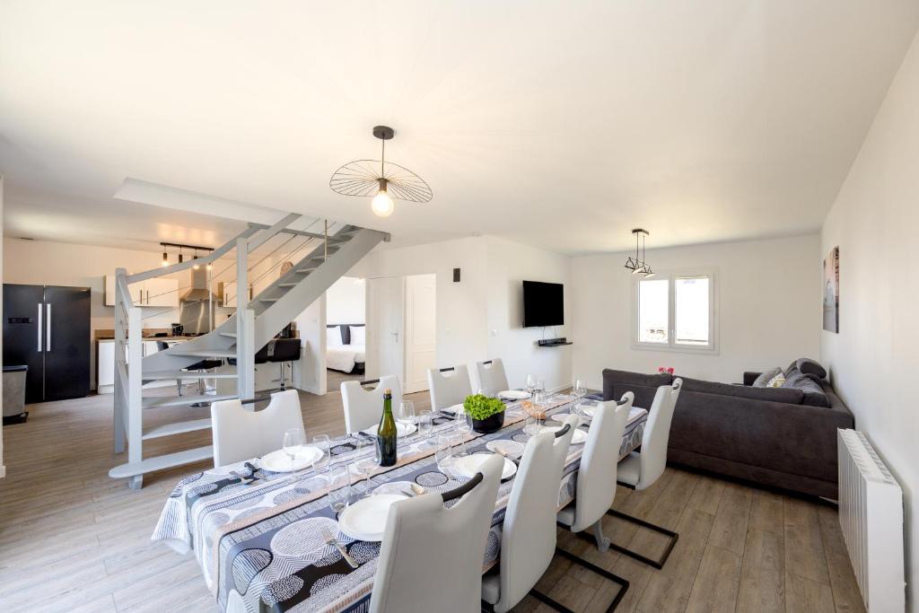 une salle à manger et un salon avec une table et des chaises dans l'établissement La Flora - Charmante maison avec jardin, à Pléneuf-Val-André