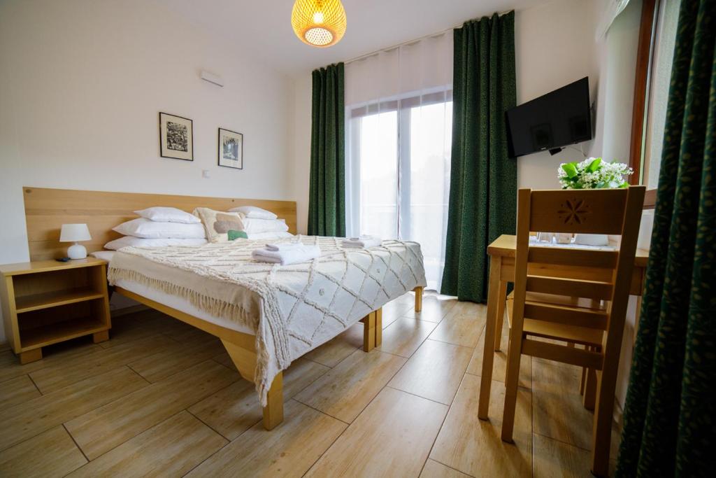una camera con letto, televisore e finestra di Cudne Manowce a Wisła