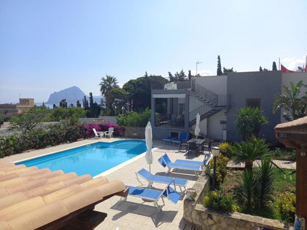 a swimming pool with lounge chairs and a house at Villa Giulia Tonnara di Bonagia in Valderice