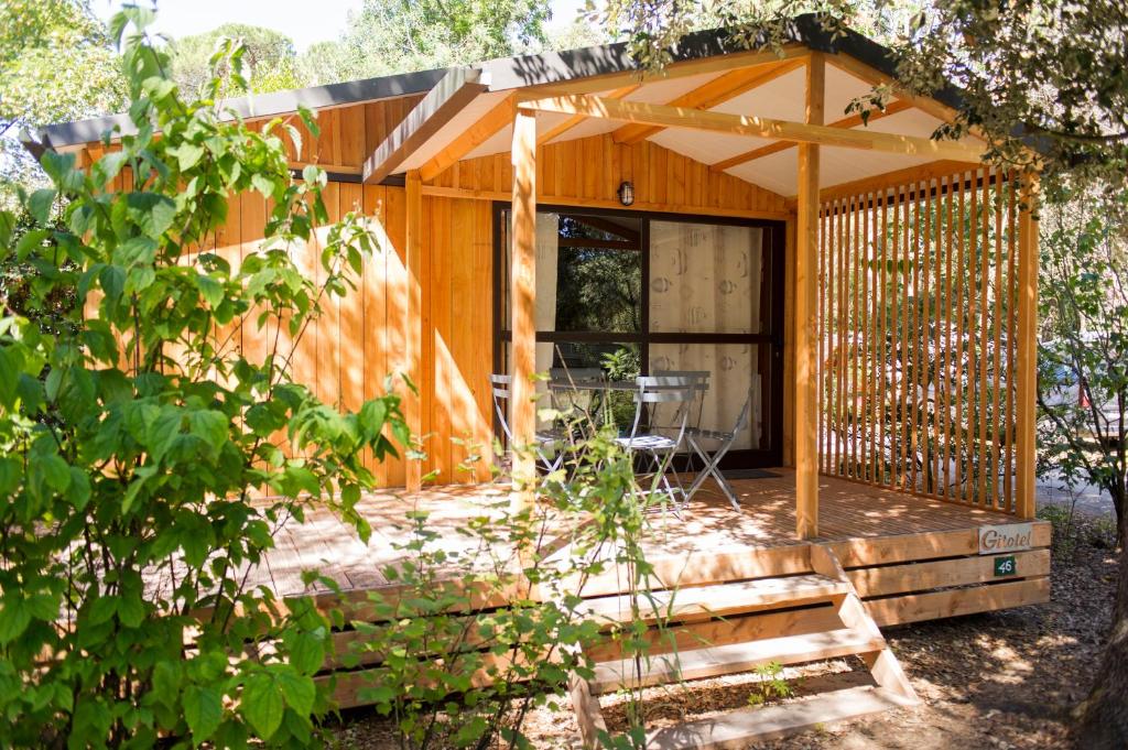 een houten hut met een afgeschermde veranda bij CityKamp Lyon in Dardilly