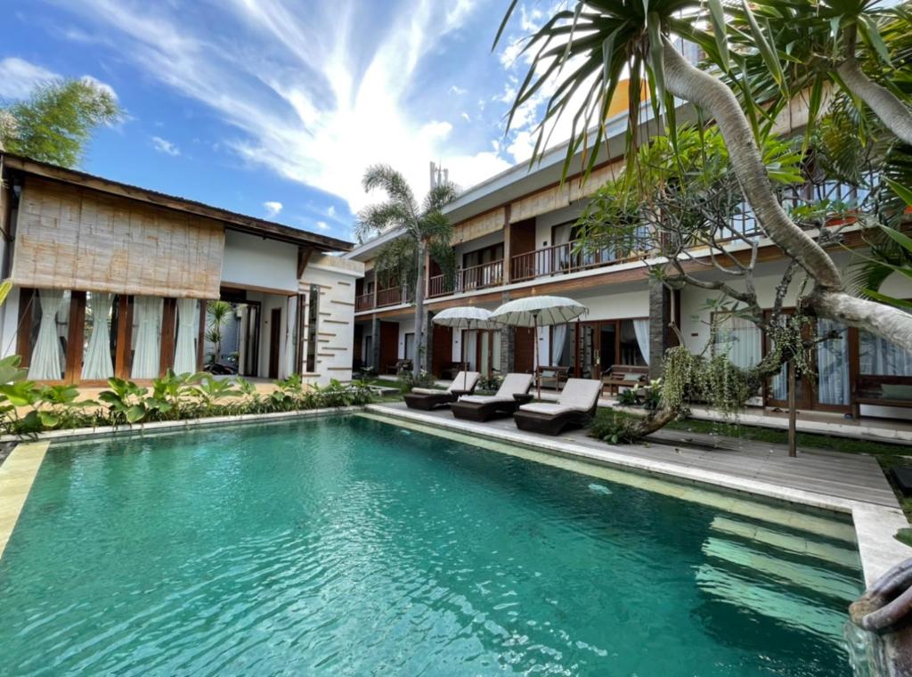 a swimming pool in front of a villa at Balcony Living Apartment in Seminyak