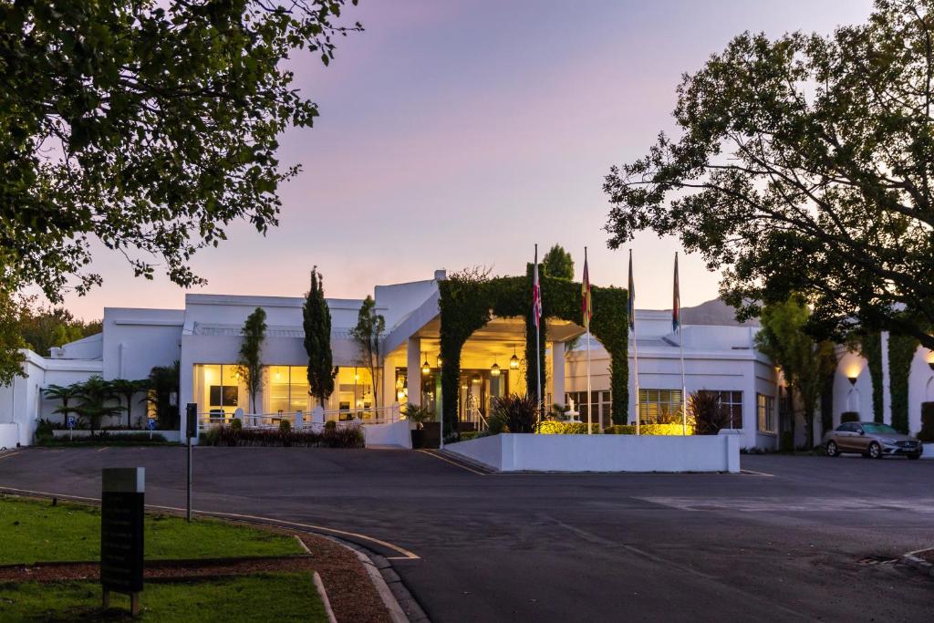 ein großes weißes Gebäude mit einer Straße davor in der Unterkunft Lord Charles Hotel in Somerset West