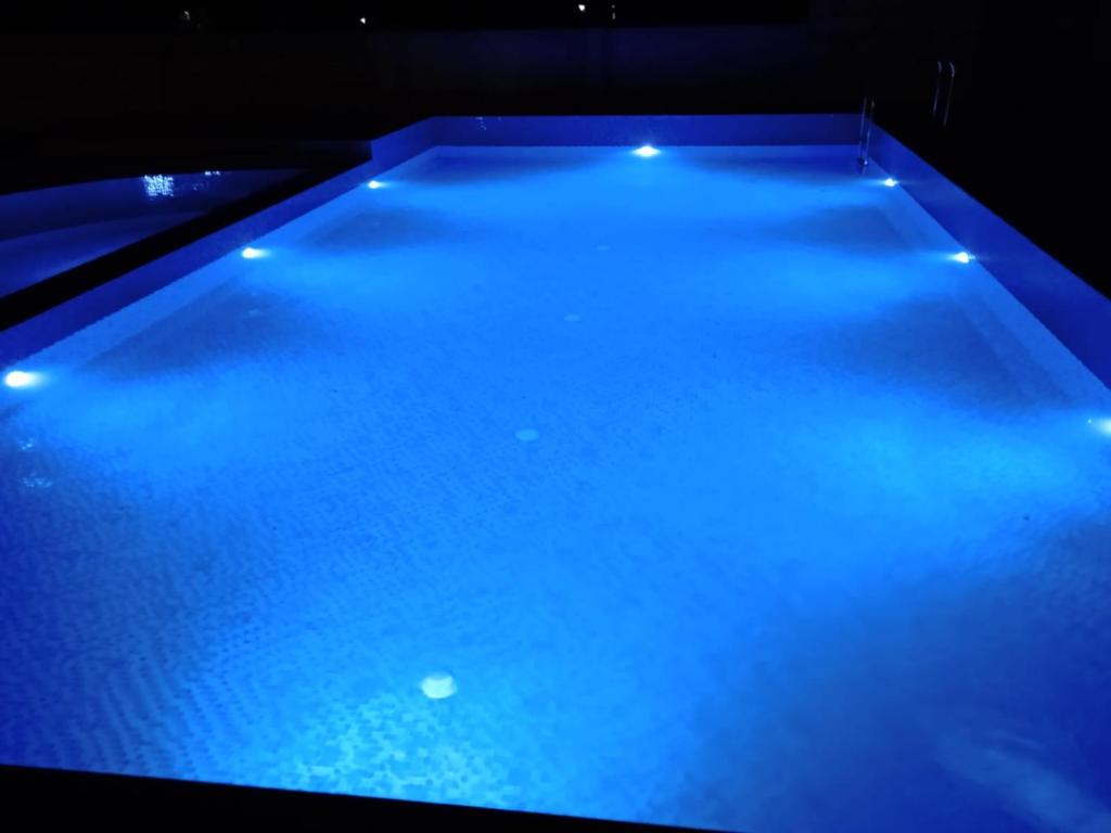 a large pool with blue lights in a room at Vasant Corbett Resort in Rāmnagar