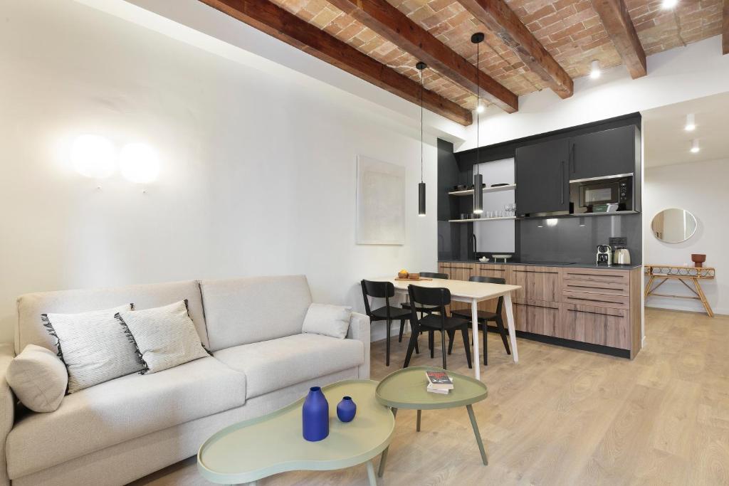 sala de estar con sofá y mesa en Diagonal Apartments by Olala Homes, en Barcelona