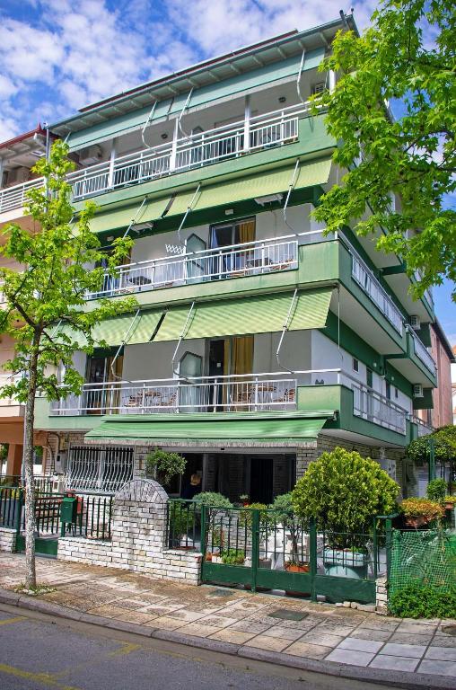 a green and white building with balconies on a street at OLGA STUDIOS in Olympic Beach