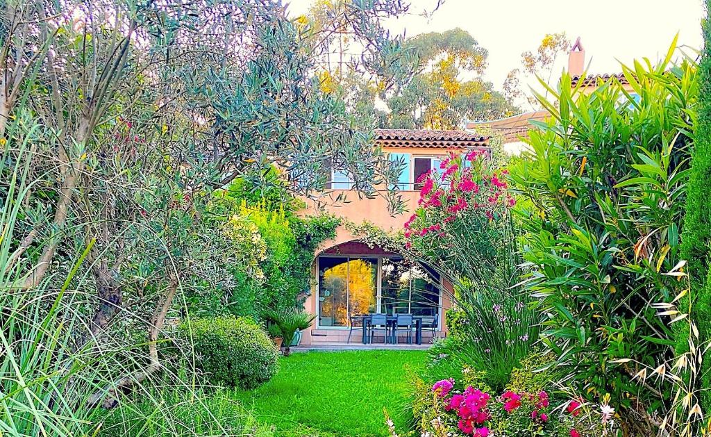 une maison avec un jardin agrémenté de fleurs et de plantes dans l'établissement Maison domaine Golf Country Club de St-Tropez, à Saint-Tropez