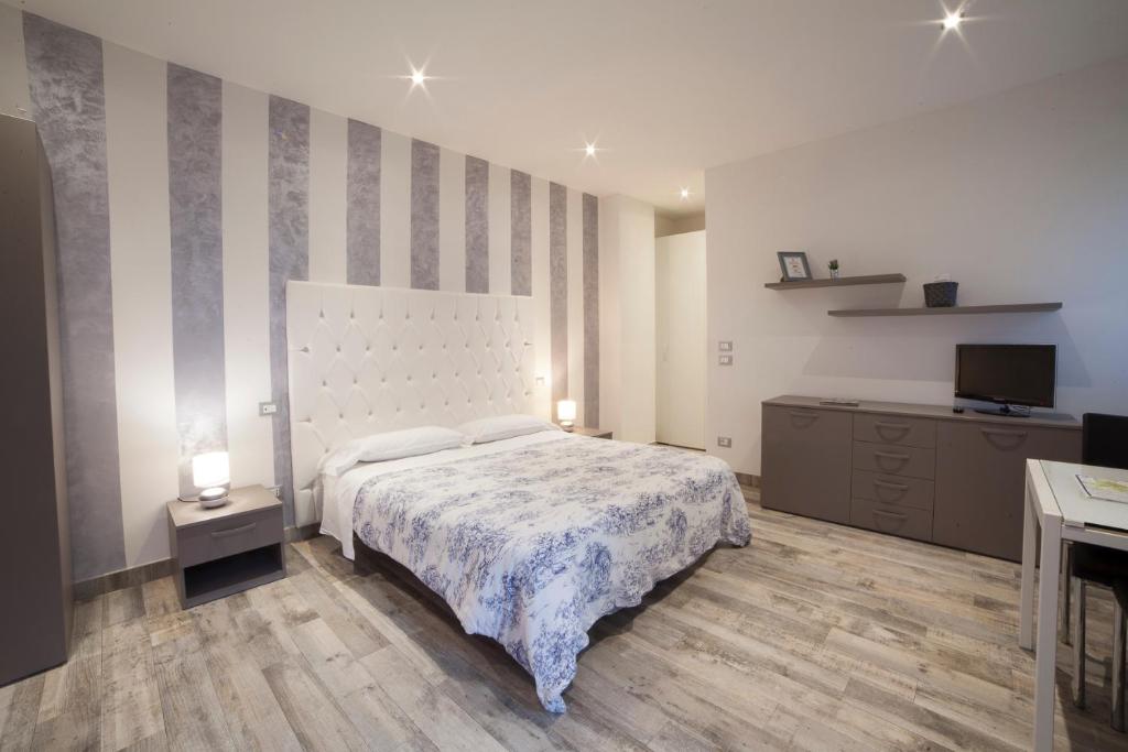 a bedroom with a bed with a striped wall at APPARTAMENTI MUSEO 3 in Verona